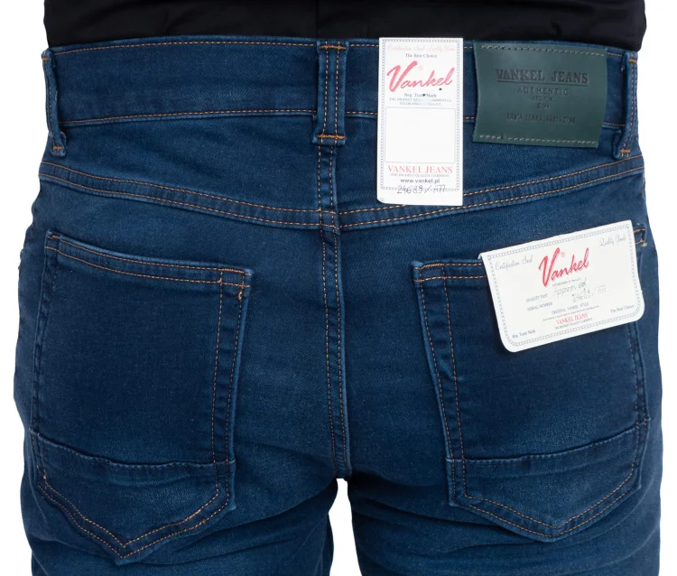 Tył granatowych jeansów slim, zbliżenie na kieszenie z metkami