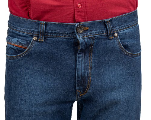 Zbliżenie na przód granatowych jeansów z brązowymi wstawkami przy kieszeni