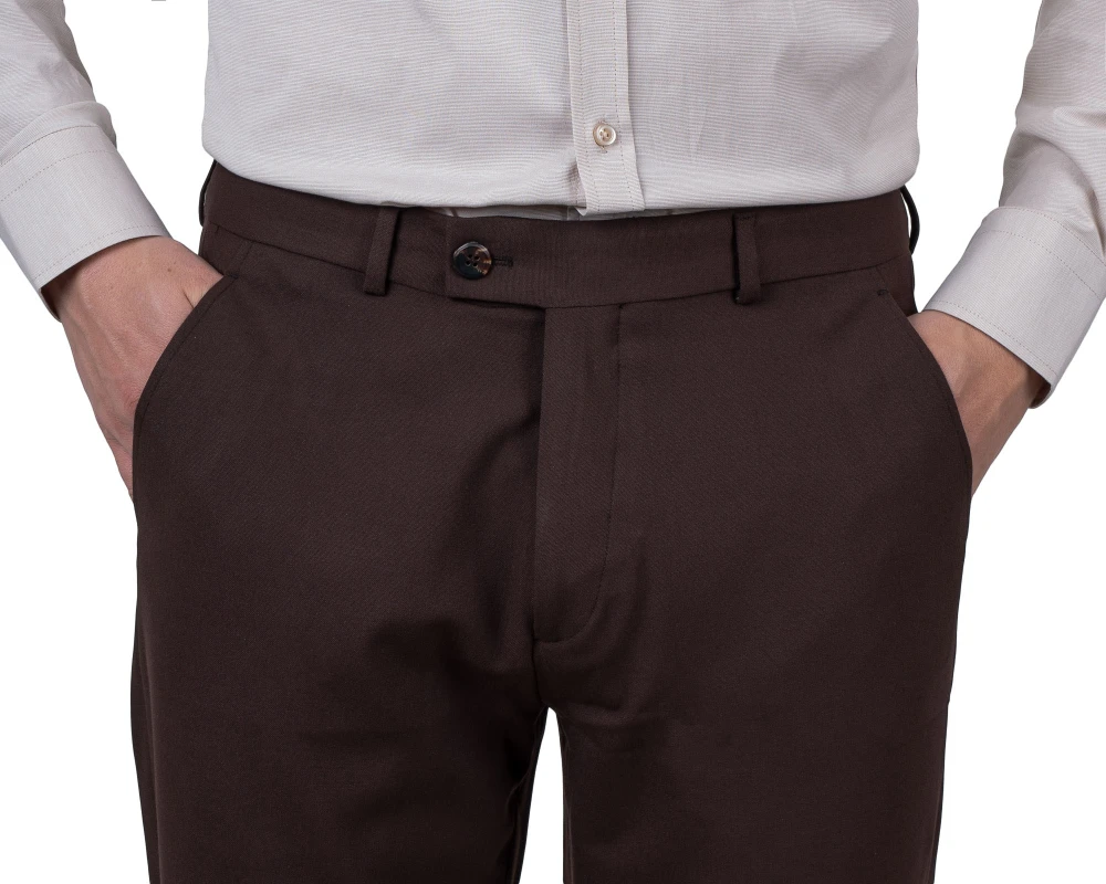 Detal pasa: brązowe spodnie wizytowe z zapięciem na guzik i szlufkami